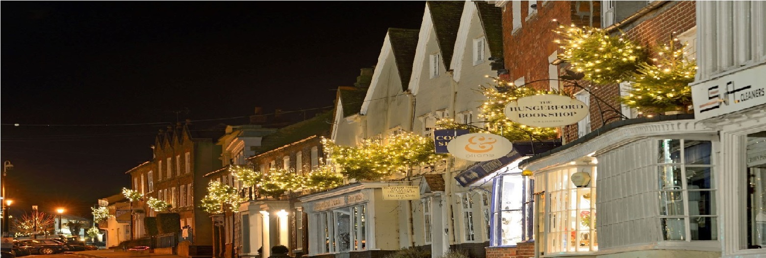 Christmas Trees with lights above High Street shops